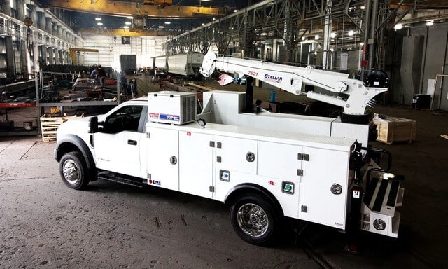 Small Mechanics Truck with a Crane Side View in a Warehouse